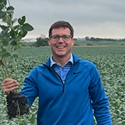 photo of Kevin Lloyd holding soy bean stalks
